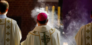 Clergy in ornate vestments during a church service with incense smoke