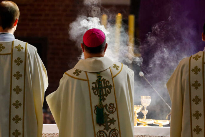 Torun,Poland,-,April,18,,2019:,Bishop,Censes,Incense,During Clergy in ornate vestments during a church service with incense smoke