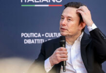 Man in suit holding microphone at event indoors