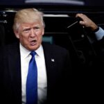 Crowd Erupts As Trump Slams Communism man in suit stepping out of a vehicle