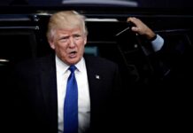 Crowd Erupts As Trump Slams Communism man in suit stepping out of a vehicle