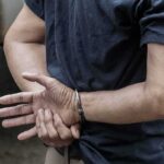 person in handcuffs with hands behind back