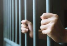 Jamaica Hideout Blown—Fraud Queen Returned hands gripping prison bars