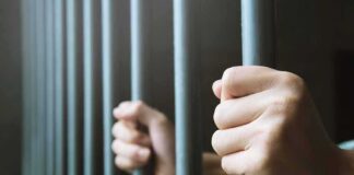 hands gripping prison bars