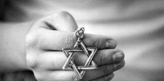 Hand holding a Star of David pendant