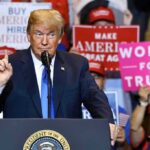 politician speaking at rally podium
