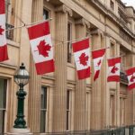 U.S.–Canada Standoff Turns Costly Canadian flags on a neoclassical building facade