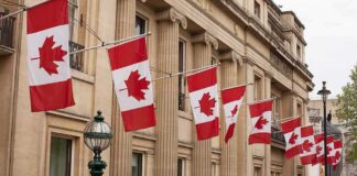Canadian flags on a neoclassical building facade