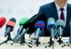 LA Power Play Muzzles Public — Lawsuit Looms microphones clustered on a table at a press conference