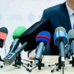 LA Power Play Muzzles Public — Lawsuit Looms microphones clustered on a table at a press conference