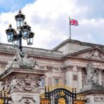 Buckingham Palace facade with Union Jack flag and ornate gate