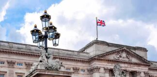 Buckingham Palace facade with Union Jack flag and ornate gate