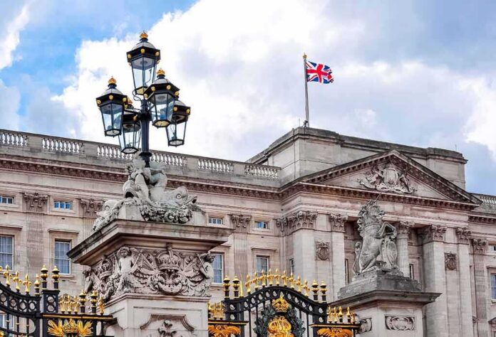 shutterstock_1254556474 Buckingham Palace facade with Union Jack flag and ornate gate