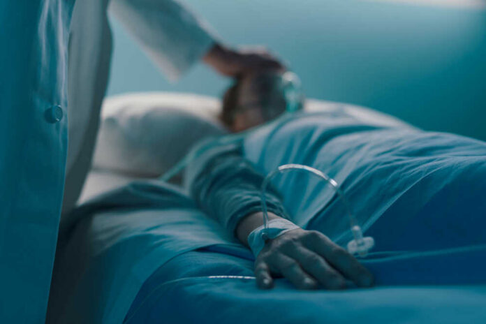 Hospitalized,Patient,Lying,In,A,Hospital,Bed,At,Night,,A A medical professional attending to a patient in a hospital bed