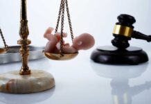 Missouri Shock: Abortion Ban Reversed Scales of justice with a small baby figurine on one side and a gavel in the background