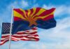 Arizona state flag waving with U.S. flags in background