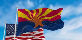 Arizona state flag waving with U.S. flags in background