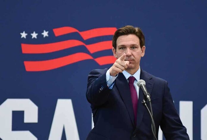 man in suit pointing while speaking at podium