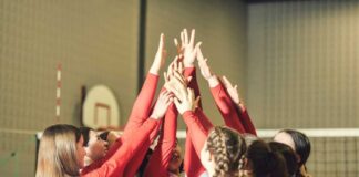 Volleyball players celebrating with hands raised together