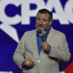 Man speaking at a conference with microphone