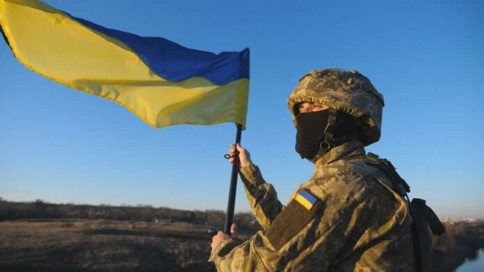 ukrainianarmyid2282691343jpg Soldier holding a Ukrainian flag outdoors