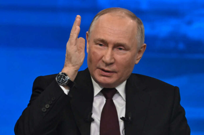 man in suit speaking with raised hand