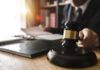 Shocking Leniency In Baby Death Case Judge's gavel on desk with person reading documents in background