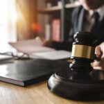 Shocking Leniency In Baby Death Case Judge's gavel on desk with person reading documents in background