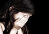 Child covering face with hands