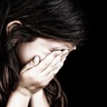 Child covering face with hands