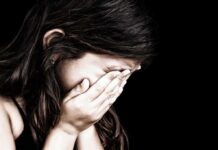 Child covering face with hands