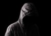 Big Claim Crumbles: One Cause Doesn’t Fit Hooded figure in shadow on black background
