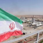 Iran’s Pumps Run Dry — Regime Digs In Iran flag over an oil and gas facility in a desert landscape