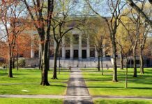 Media ‘Lynching’ Claim Ignites Cambridge Firestorm Students walking on a university campus with autumn trees and a historic building in the background