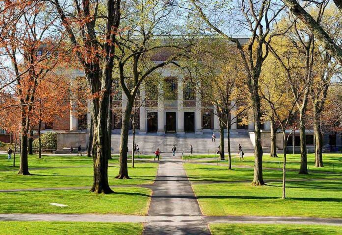 shutterstock_131270519 Students walking on a university campus with autumn trees and a historic building in the background