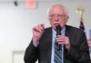 Elderly man speaking into a microphone