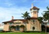 Mediterranean Revival mansion with tower and palm trees
