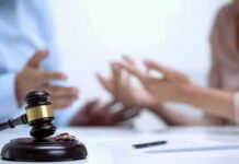 Judge's gavel with wedding rings as two people argue in background