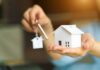 Decades-Long Deals Trap Military Families Hands holding a house model and a key with house-shaped keychain