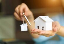 Decades-Long Deals Trap Military Families Hands holding a house model and a key with house-shaped keychain