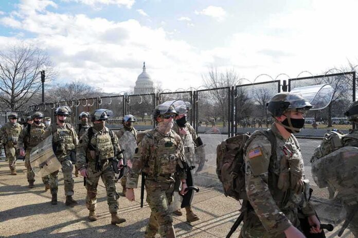 shutterstock_1900668535 Soldiers in riot gear patrol near a fenced government building