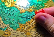 Midnight Call Triggers Daring Kabul Escape Hand placing a red pushpin on Afghanistan on a map