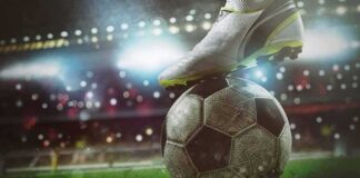 soccer cleat on a ball under stadium lights
