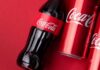 Coca-Cola bottle and cans on red background