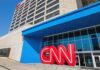 Exterior view of the CNN headquarters with a large red logo and blue entrance