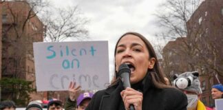 woman speaking into a microphone at an outdoor protest