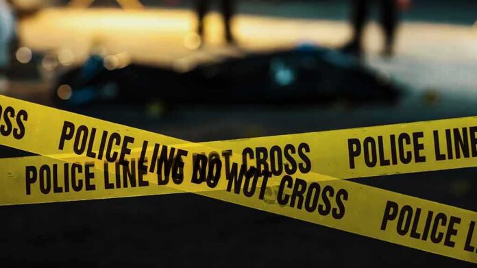 shutterstock_2230640045 yellow police tape at a nighttime crime scene