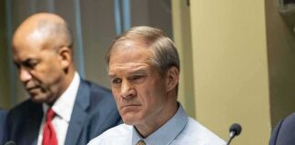 Man in a light blue shirt and tie at a meeting table