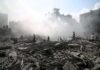 People walking through smoke-filled urban rubble