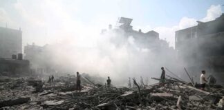 People walking through smoke-filled urban rubble